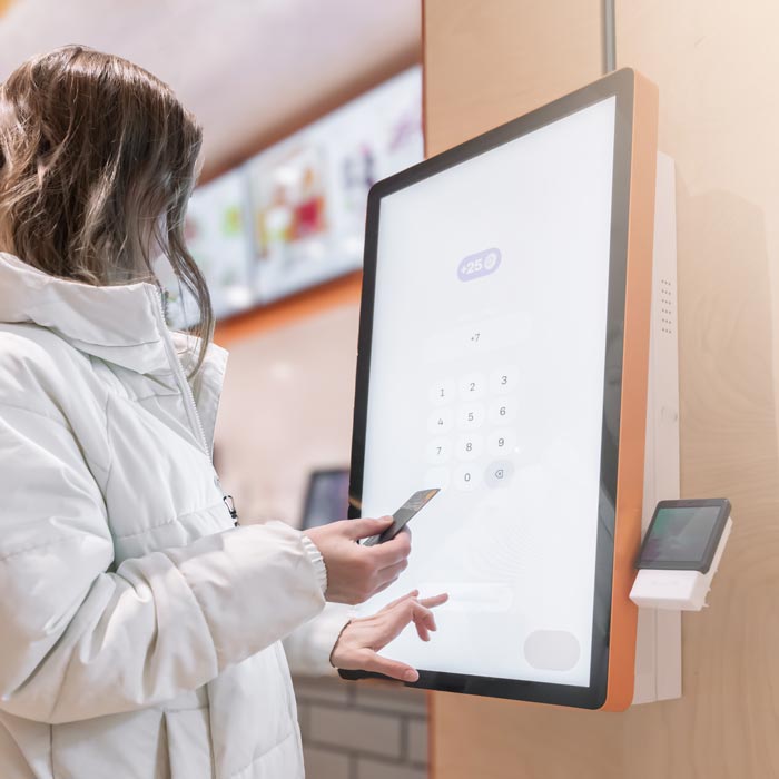woman using touch kiosk